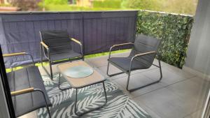 three chairs and a table on a balcony at Apartament Mickiewicza in Staszów