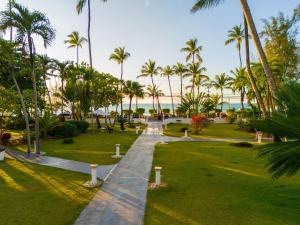 a walkway through a park with palm trees at apartement rooftop oceanfront - Hotel Aligio in Las Terrenas