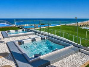 a hot tub with the ocean in the background at Infinity View Penthouses by NRAS in Arenales del Sol