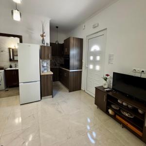 a kitchen with a white refrigerator and a tv at Baloma Apartment in Falasarna +19 photos