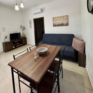 a living room with a wooden table and a couch at Baloma Apartment in Falasarna