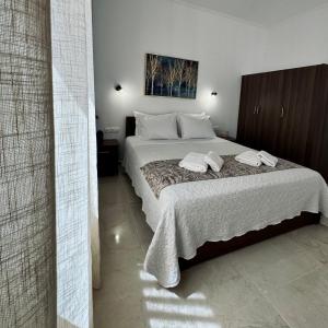 a bedroom with a bed with two towels on it at Baloma Apartment in Falasarna