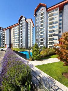 a row of tall apartment buildings with a garden at Departamento Villarrica Vista al Volcán y Piscina in Villarrica