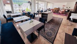 a restaurant with tables and chairs in a room at Gästehaus Am Rebenhang in Mehring +21 photos