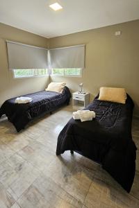 two beds sitting in a room with at Vi Hosting Cabañas in Salta +51 photos