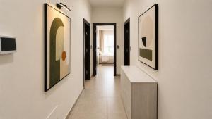 a hallway with paintings on the walls at The Arco Rooms in Pomigliano dʼArco