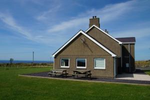a building with a picnic table and a bench in front of it at Hendy Iago in Aberdaron