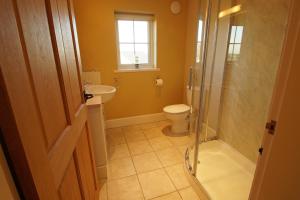 a bathroom with a toilet and a sink and a shower at Hendy Iago in Aberdaron +19 photos