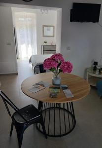 a room with a table with a vase of flowers on it at Poggio sul Mare in Alberese