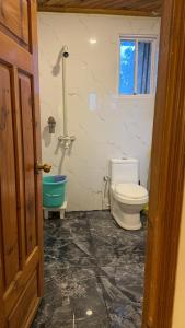 a bathroom with a toilet and a tub at Umda Hotel in Nathia Gali