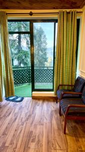 a living room with a couch and a large window at Umda Hotel in Nathia Gali