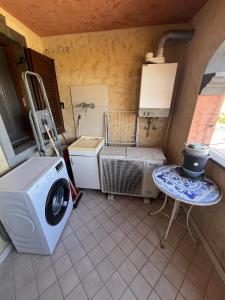 a room with a washing machine and a table at Alma's house in Donigala Fenughedu