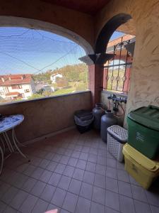 a balcony with two trash cans and a window at Alma's house in Donigala Fenughedu