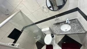 a bathroom with a sink and a toilet and a mirror at Mini apê de luxo montese in Fortaleza