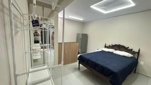 a bedroom with a bed with a blue comforter at Mini apê de luxo montese in Fortaleza