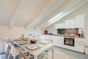 a dining room with a table and chairs in a kitchen at Loft & Jacuzzi - Happy Rentals in Riva del Garda