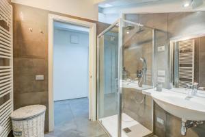 a bathroom with two sinks and a glass shower at Loft & Jacuzzi - Happy Rentals in Riva del Garda