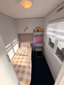 a small room with two beds and a window at Hoopers Hideaway Caravan Rental SetonSands 2 in Port Seton