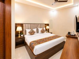a hotel room with a bed and a television at Hotel Urban Inn - The RK Hospitality Group #Prem Mandir #Chaar Dham Fully AC in Vrindāvan