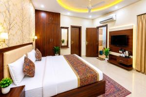a bedroom with a large bed and a television at Hotel Urban Inn - The RK Hospitality Group #Prem Mandir #Chaar Dham Fully AC in Vrindāvan