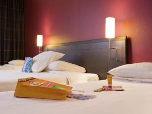a hotel room with two beds and a bag on the bed at Ibis Styles Metz Centre Gare in Metz