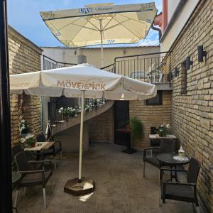 a patio with an umbrella and tables and chairs at IMAGINATOR RESIDENCE-Pool is extra pay- Parking 2 free space in Novi Sad