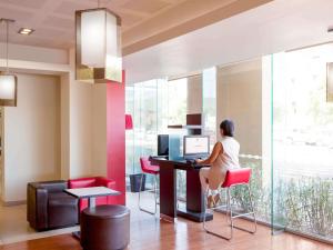 a woman sitting at a desk in front of a computer at Ibis Hermosillo in Hermosillo