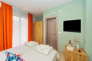 a bedroom with a bed and a flat screen tv at Hotel Solaris in Čanj