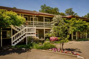 a house with a white staircase and flowers in front of it at The Jack London Lodge in Glen Ellen