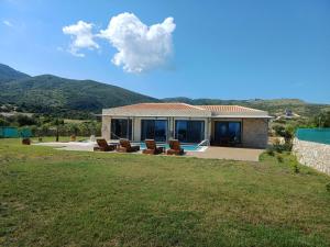 a house with chairs sitting in a yard at Pantheon Luxury Villas in Skala