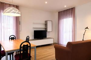a living room with a dining table and a television at WELCOME residenza esclusiva via Liverani Imola in Imola