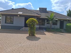 a house with a tree in front of it at Nduna Legacy Lodge in Harare +18 photos