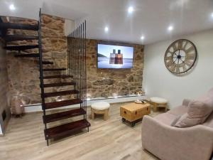 a living room with a staircase and a stone wall at Casa o Sabio in Fisterra
