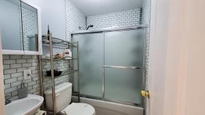 a bathroom with a shower with a toilet and a sink at House - Bungalow in Hamilton