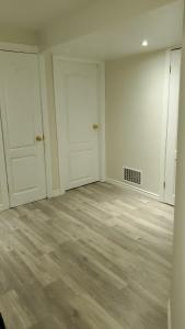 an empty room with white walls and wooden floors at House - Bungalow in Hamilton