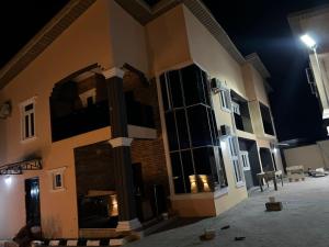 a large building at night with a street light at sky 7 hotel & apartment in Akure