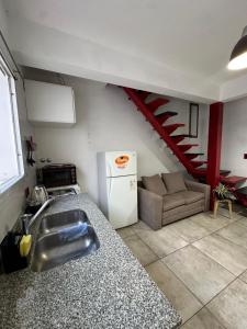 a kitchen with a sink and a couch in a room at Mini casita a in Rosario +4 photos