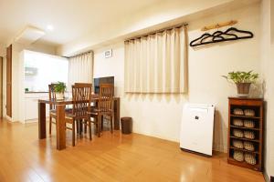 a dining room with a table and chairs and a refrigerator at Sarangbang in Kyoto