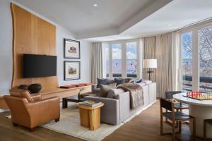 a living room with a couch and a tv at Viewline Resort Snowmass, Autograph Collection in Snowmass Village