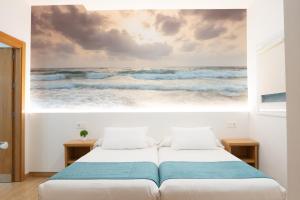 a bedroom with a painting of the ocean at Musika Plaza in Zarautz