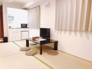 Il comprend un salon avec une table et une cuisine. dans l'établissement Sarangbang, à Kyoto