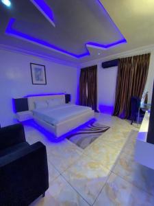 a bedroom with a bed and a couch and purple lights at D-SHA Apartments in Aja