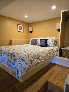 a bedroom with a bed with blue and white sheets at Cozy Sanctuary in Saltspring Island