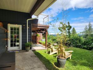 a house with a patio with benches on the grass at Cozy Sanctuary in Saltspring Island