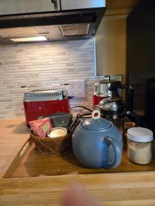 a kitchen counter with a tea pot and a basket of food at Cozy Sanctuary in Saltspring Island +8 photos