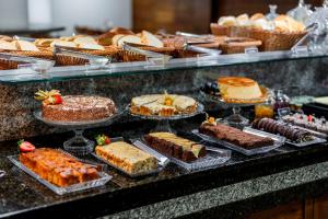 a display of cakes and other desserts on a counter at Romas Hotel in Umuarama