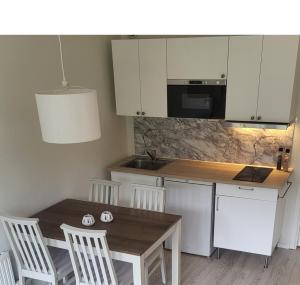 a kitchen with a wooden table and white cabinets at Lägenhet i Strömstad in Strömstad
