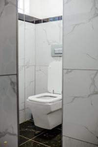 a white toilet in a bathroom with a glass door at Makay's Guests House in Kimberley