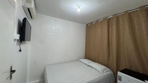 a small room with a bed and a television at Pousada Point da Nanda in Juazeiro do Norte