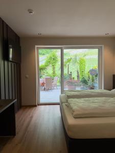 a bedroom with a bed and a sliding glass door at Hotel Harpf in Bressanone